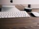 selective focus photography if silver iMac, Apple wireless keyboard, Magic Mouse, and black Amazon Echo Dot 2nd generation at table